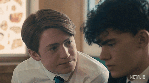two young men looking at each other with a netflix logo on the bottom