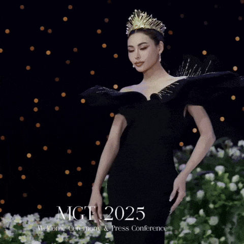 a woman wearing a black dress and a crown stands in front of mgt 2025