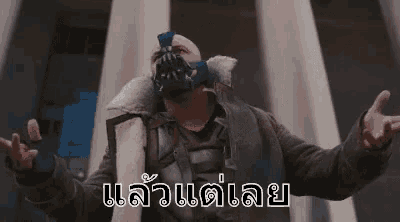 a man wearing a gas mask is standing in front of a building with his arms outstretched .
