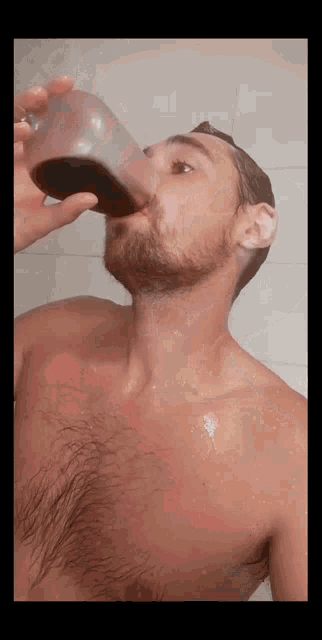 a shirtless man drinking from a glass with his mouth open