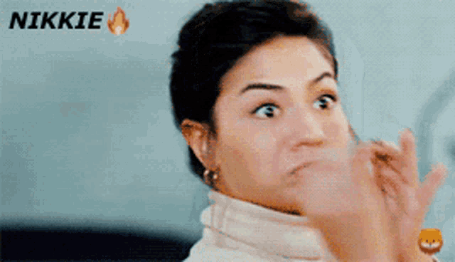 a woman is making a funny face with the word nikkie behind her