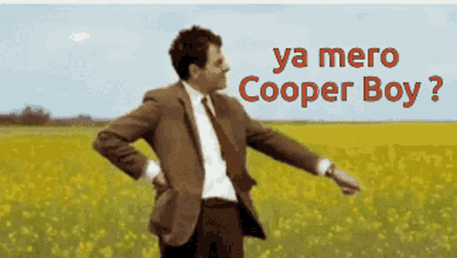 a man in a suit and tie is standing in a field with the words ya mero cooper boy written above him