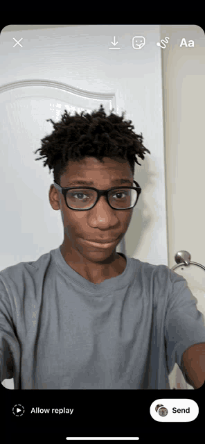 a young man wearing glasses is taking a selfie on a phone