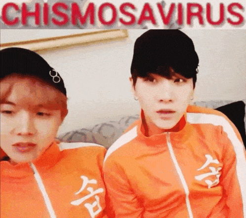 two young men wearing orange jackets and hats are sitting next to each other in front of a sign that says chismosaverus