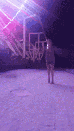 a blurry picture of a woman walking in front of a ferris wheel