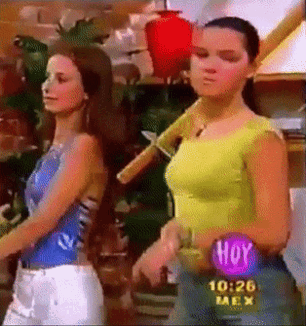 two women are standing next to each other in front of a screen that says hoy