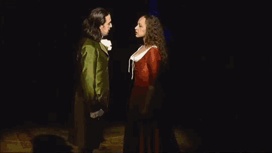 a man and a woman are standing next to each other in a dark room .