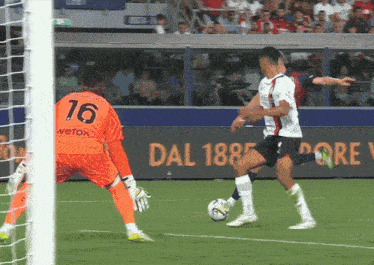 a soccer player with the number 16 on his jersey kicks the ball