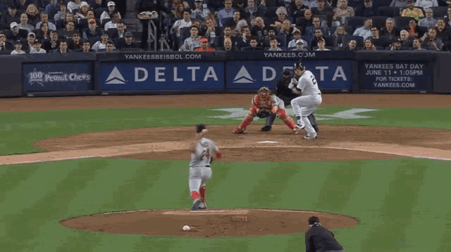 a yankees baseball player swings at a pitch