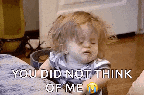 a little girl is sitting at a table with her eyes closed and a tear coming out of her eye .