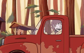 a person is driving a red truck through a forest .