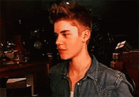 a young man in a denim shirt is looking at something