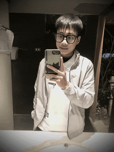 a man taking a picture of himself in a mirror with a phone case that says converse