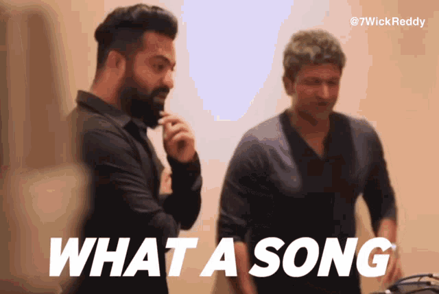 two men are standing next to each other and the words what a song are on the screen