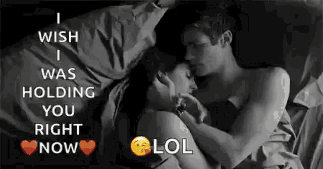 a man and a woman are hugging in bed .