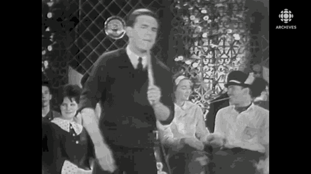 a black and white photo of a man holding a microphone with the words archive on the bottom right