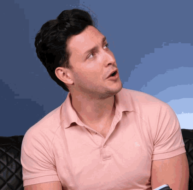a man wearing a pink polo shirt with a white embroidered abercrombie logo