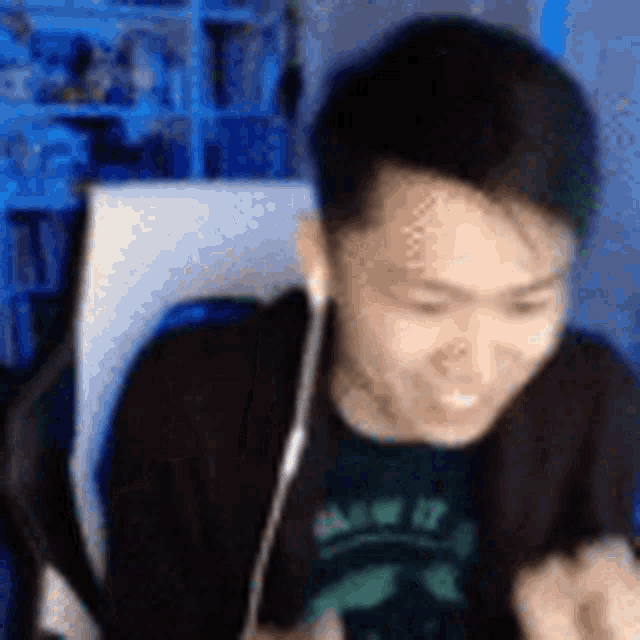 a man wearing headphones is sitting in a chair in front of a computer .