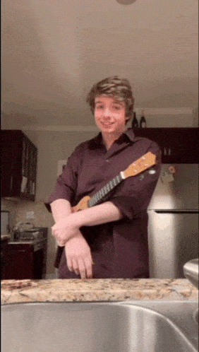 a man in a purple shirt holding a guitar
