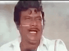 a man with a mustache is making a funny face .