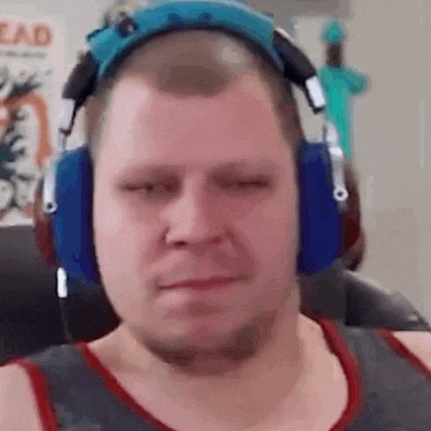 a man wearing headphones is sitting in a chair and making a funny face .