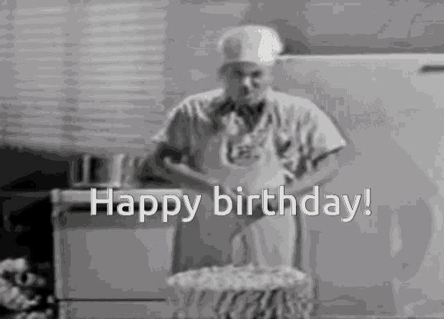 a black and white photo of a man cutting a birthday cake