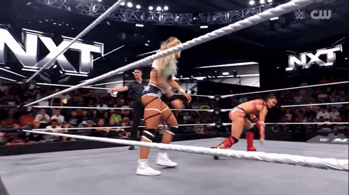two women in a wrestling ring with nxt written on the wall