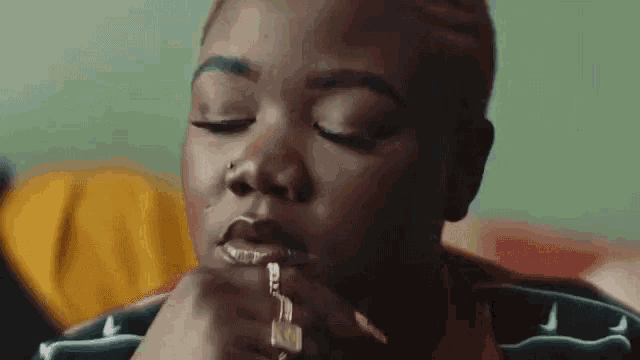 a close up of a woman 's face with a key in her mouth .