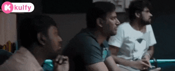 three men are sitting in a room playing a video game with a kulfy logo in the corner .