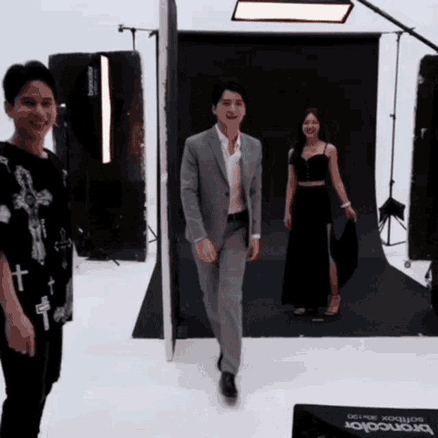 a man in a suit stands next to a woman in a black dress