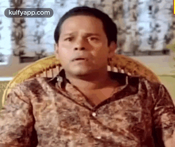 a man is sitting in a chair with his mouth open .