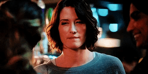 a close up of a woman 's face with a man smiling in the background .
