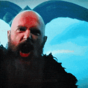 a bald man with a beard is screaming with his mouth wide open