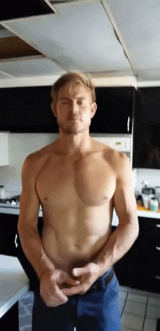 a shirtless man is standing in a kitchen