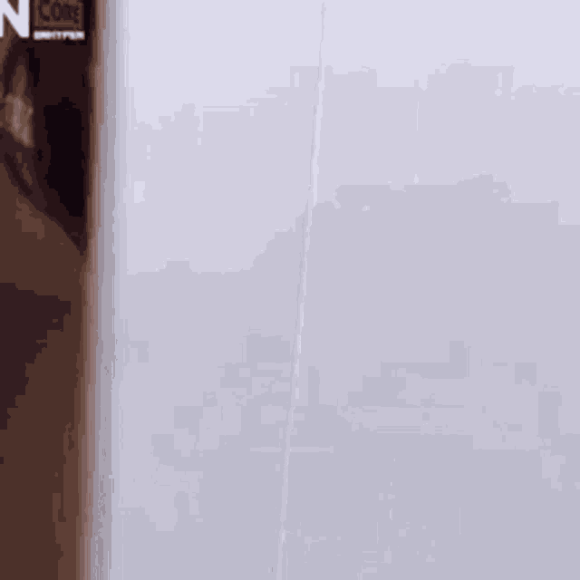 a close up of a woman 's face peeking out from behind a white wall .
