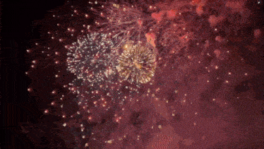 a fireworks display in the night sky with a red background