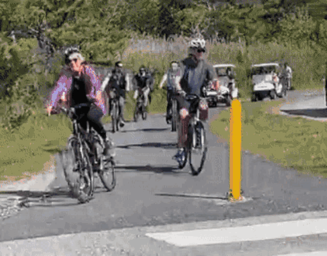 a group of people are riding bicycles down a road