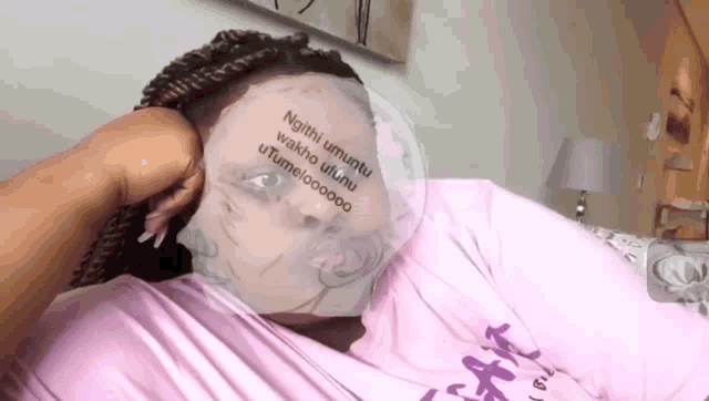 a woman laying on a bed with a mask on her face that says ngithi umuntu