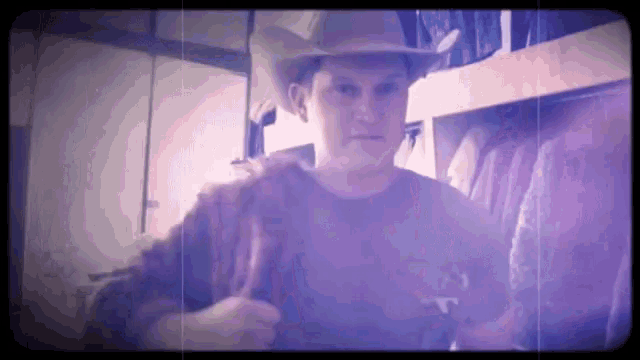a man in a cowboy hat is standing in a room