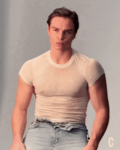 a man is wearing a white t-shirt with the letter c on the bottom right