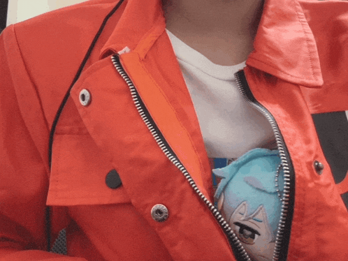 a person wearing a red jacket with a stuffed animal in the pocket
