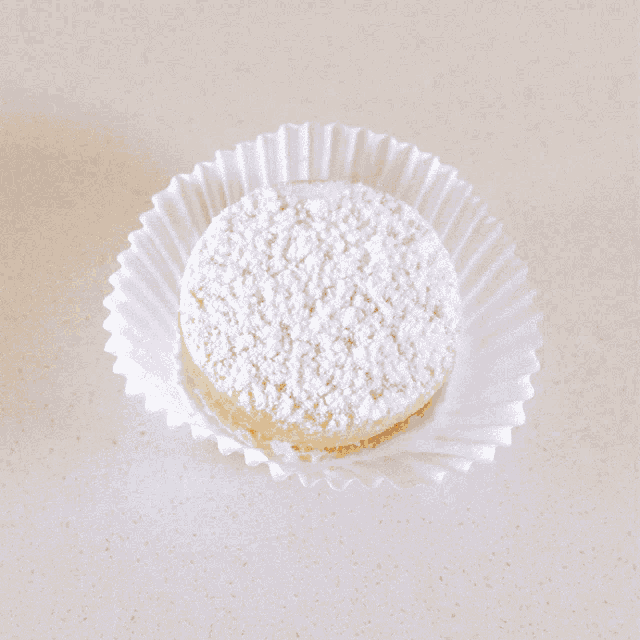 a piece of cake with powdered sugar on top in a paper wrapper