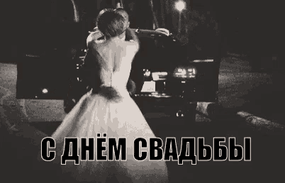 a bride and groom are dancing in front of a car in a black and white photo .