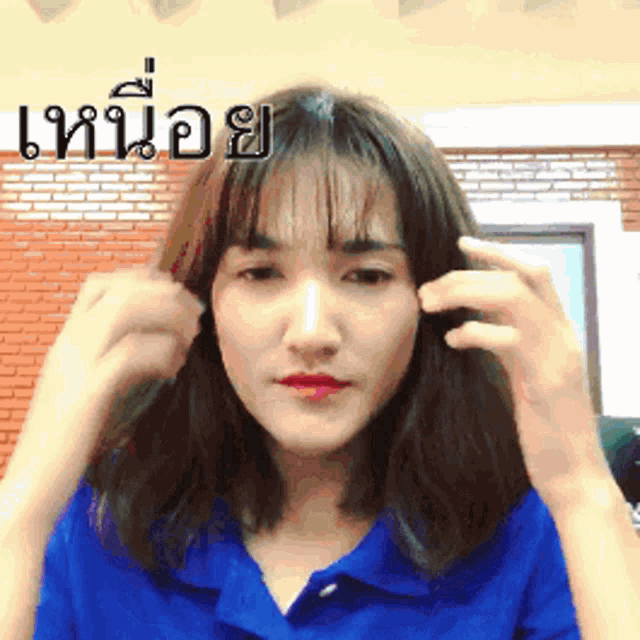 a woman in a blue shirt has a foreign language written on her face