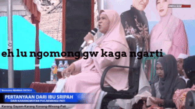 a woman sitting in a chair speaking into a microphone with the words " eh lu ngomong gw kaga ngarti " behind her