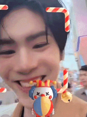 a close up of a person 's face with a toy clown and candy canes