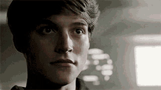 a close up of a young man 's face looking up at the camera .