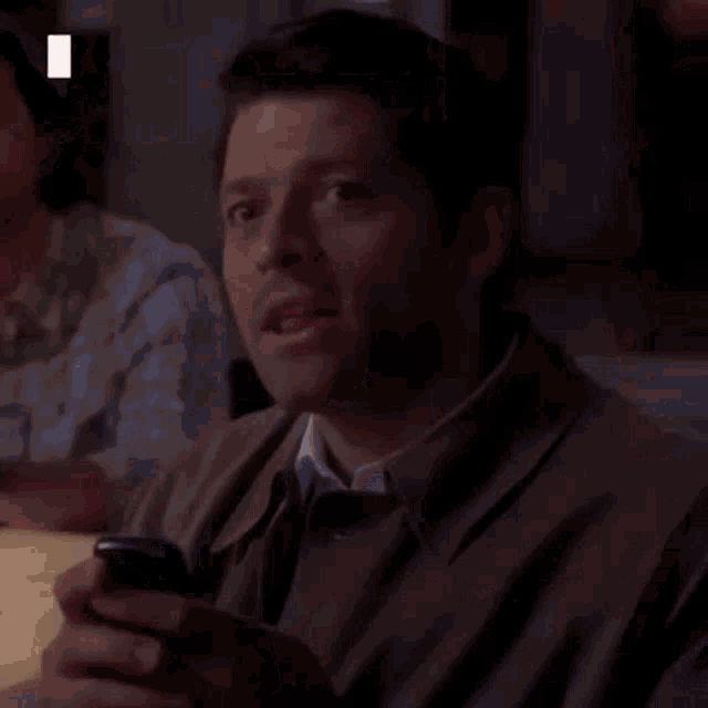 a man is holding a cell phone in his hand .