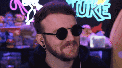 a man wearing sunglasses is smiling in front of a sign that says ' puke '