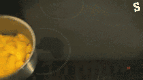 a pot filled with sliced mangoes is on a stove top